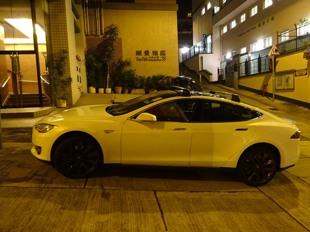 Tesla Model S blanco aparcado de noche en una calle de Hong Kong